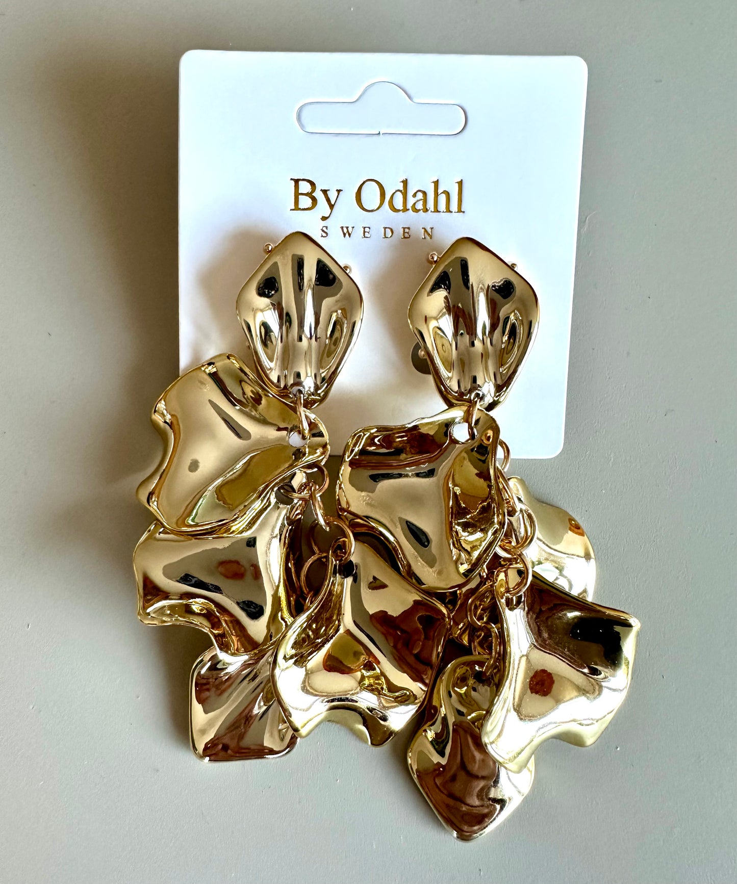 Guldfärgade lövörhängen från by Odahl med en tunn och stilren design. Perfekt för en elegant och modern look.