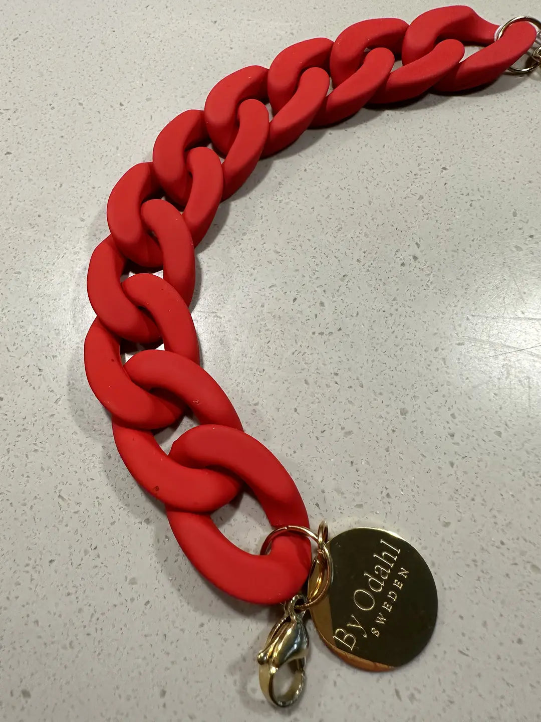 röd kedjearmband i plast, perfekt att matcha med kedjehalsband.