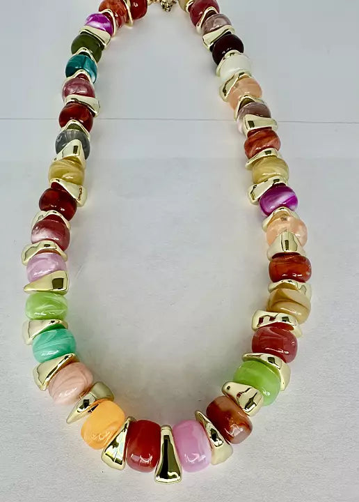 Flerfärgat halsband med pärlor i rosa, grönt, gult och rött samt guldfärgade detaljer.