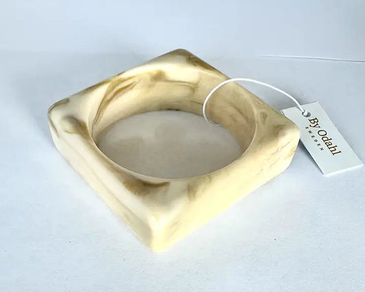 Krämfärgat fyrkantigt resinarmband från By Odahl med marmorerad finish.