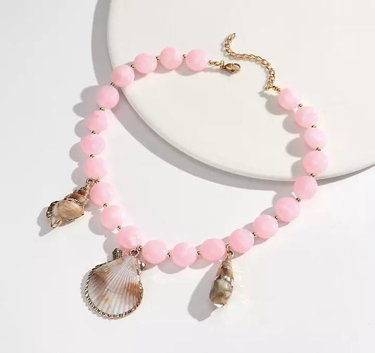 Rosa snäckhalsband med gulddetaljer