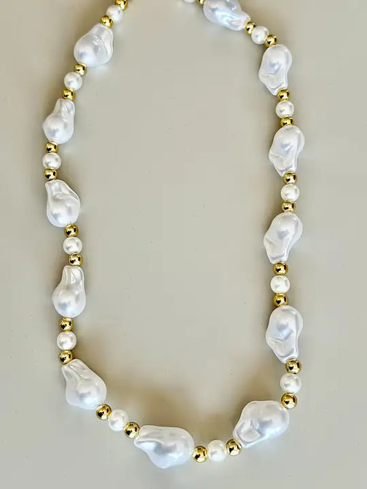 Närbild på elegant pärlhalsband med guldfärgade detaljer