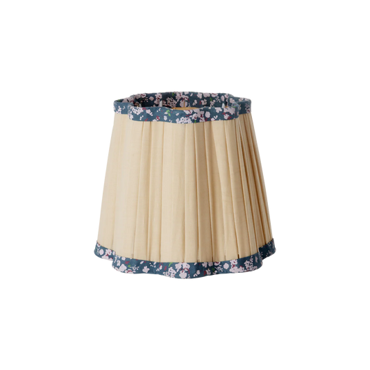 Lampskärm i sandfärgat veckat tyg med blommig kant