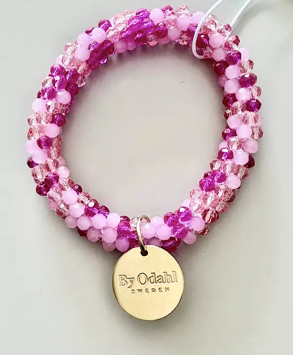 Pärlarmband i rosa från by Odahl, liggande på vit bakgrund
