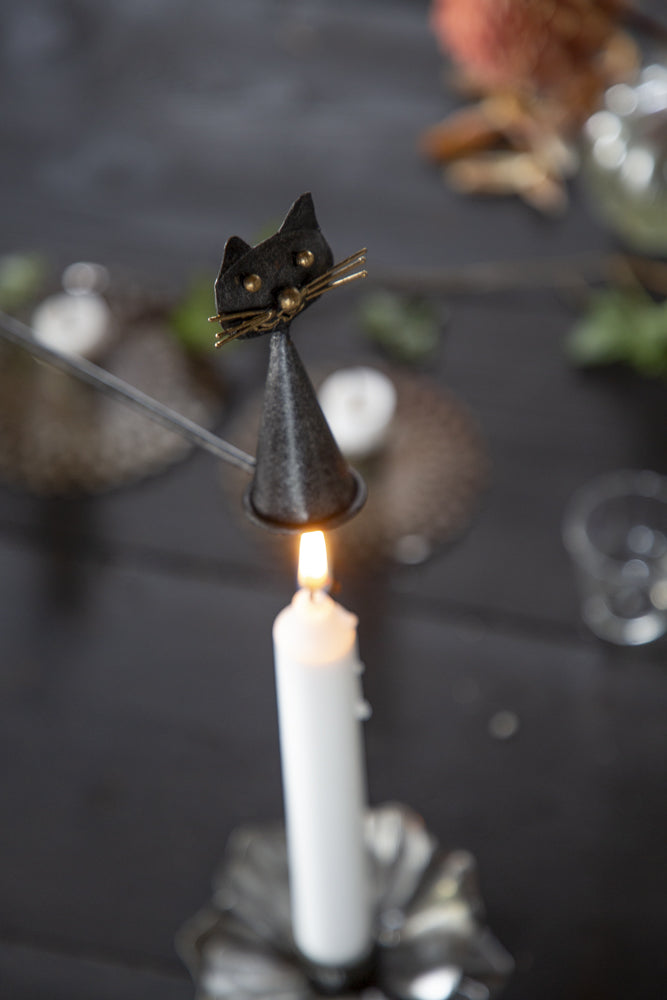 Ljussläckare i hamrad plåt med kattmotiv – stilfull och praktisk inredningsdetalj.