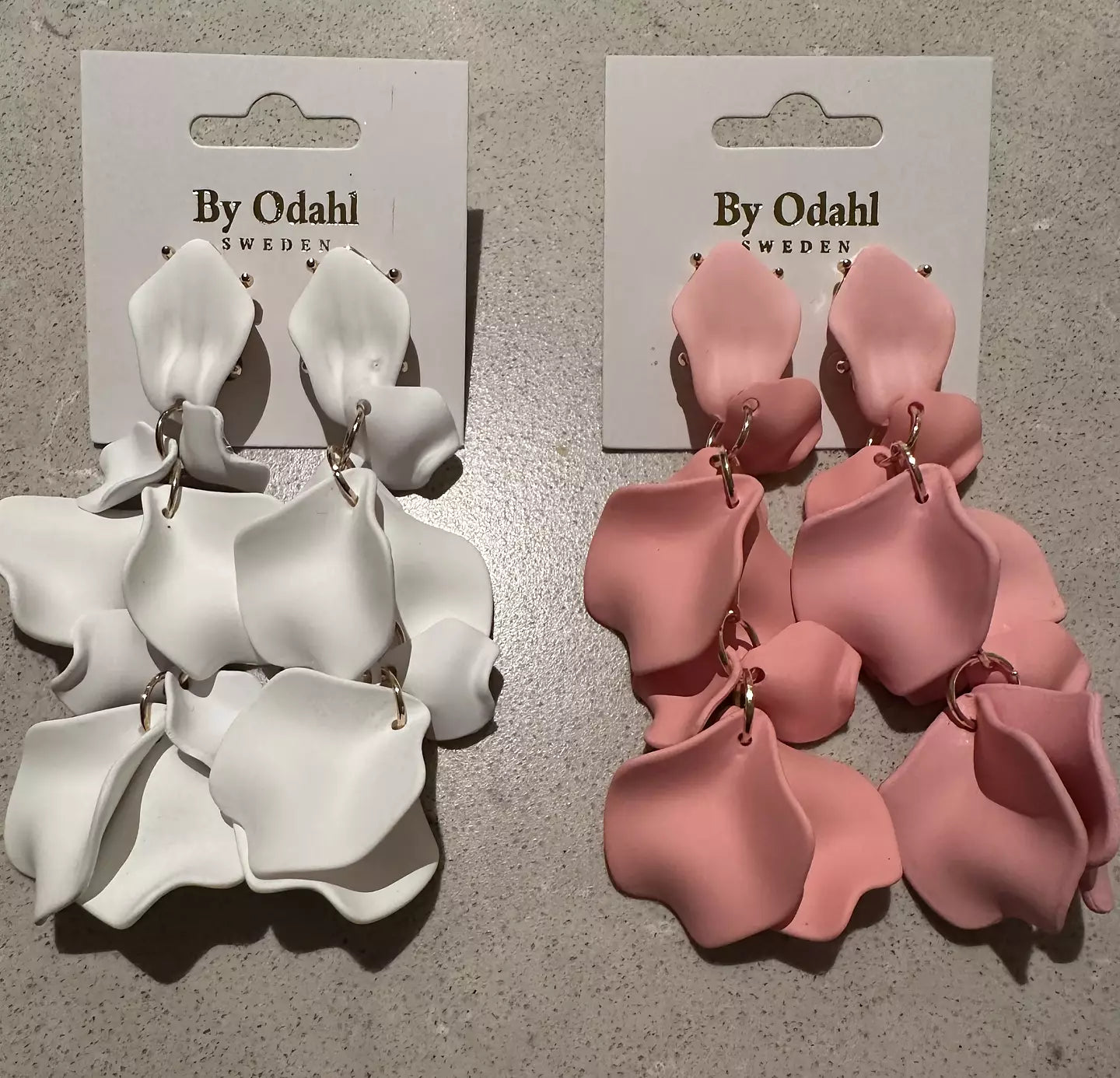 Vita & Rosa lövörhängen från by Odahl med en tunn och stilren design. Perfekt för en elegant och modern look.
