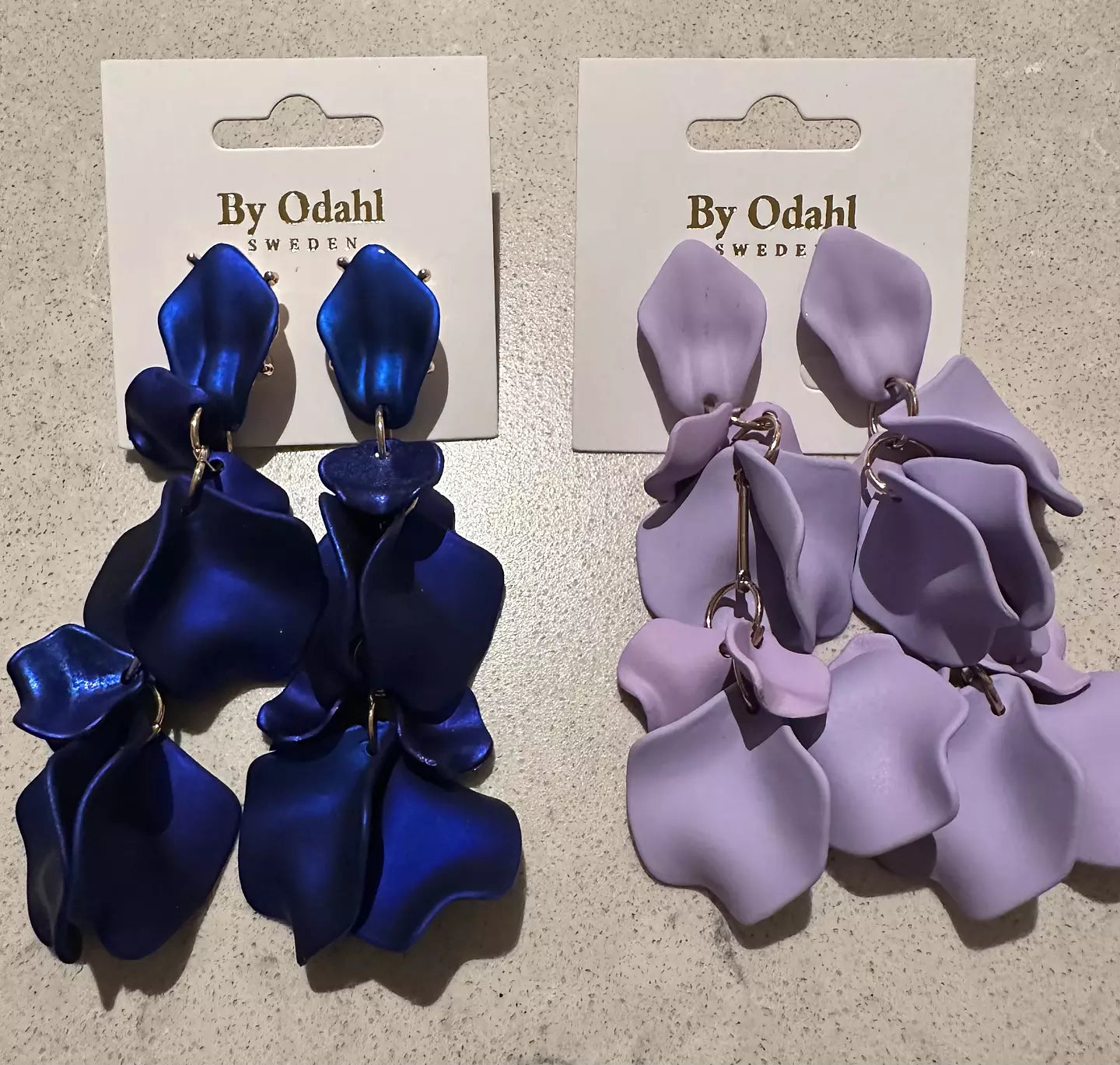 Blå och Lila lövörhängen från by Odahl med en tunn och stilren design. Perfekt för en elegant och modern look.
