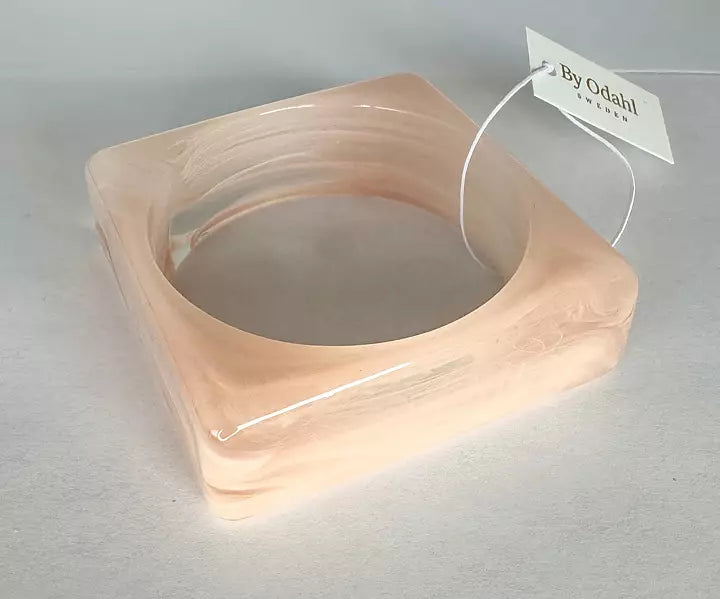 Ljusrosa fyrkantigt resinarmband från By Odahl med marmorerad finish.