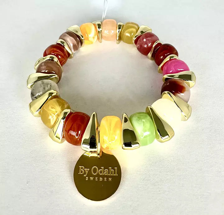 Elastiskt armband med färgade pärlor i rosa, grönt, gult och creme samt guldfärgade detaljer och rund bricka.