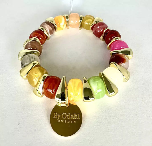 Elastiskt armband med färgade pärlor i rosa, grönt, gult och creme samt guldfärgade detaljer och rund bricka.