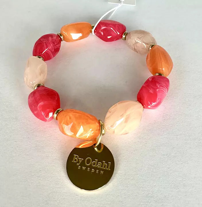 Elastiskt pärlarmband med pärlor i rosa, persika och orange nyanser samt guldfärgad berlock.