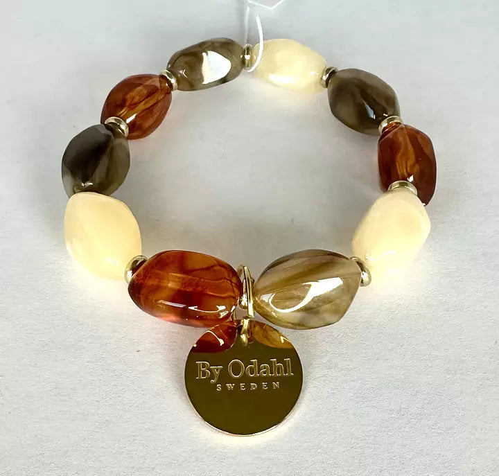 Elastiskt pärlarmband med pärlor i beige, bruna och naturfärgade toner samt guldfärgad berlock.