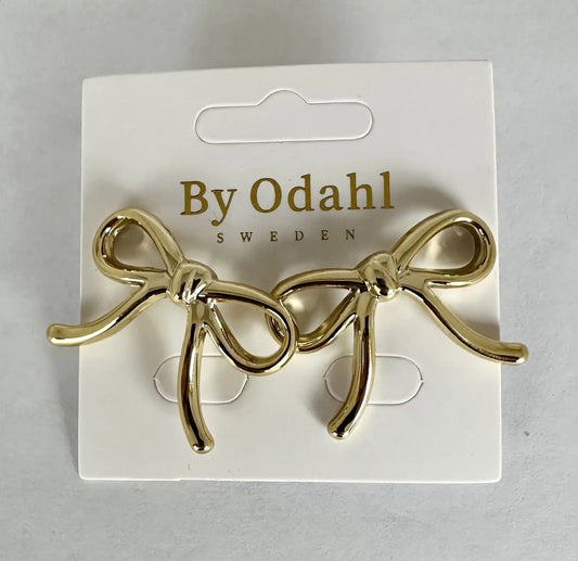 Guldfärgade örhängen formade som dekorativa rosetter från By Odahl.