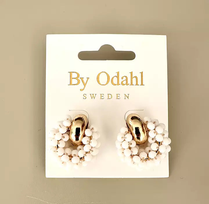 Örhängen med guldfärgade detaljer omgivna av en krans av små vita pärlor.