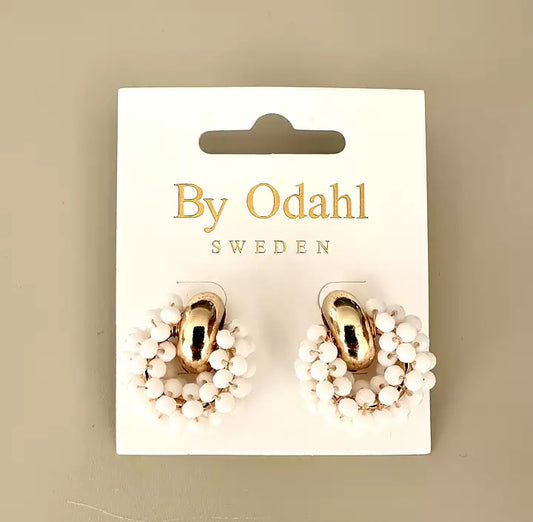 Örhängen med guldfärgade detaljer omgivna av en krans av små vita pärlor.