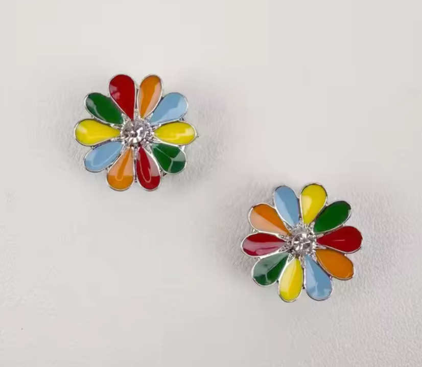 Färgglatt knappsmycke i blomform med emaljblad i rött, grönt, blått och gult samt klar sten i mitten.