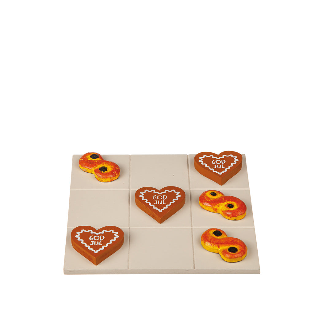 Tre i Rad-spel i trä med motiv av lussekatter och pepparkakor på en spelplan i storlek 19x19 cm. Ett julinspirerat brädspel med charmig design och klassisk spelkänsla.