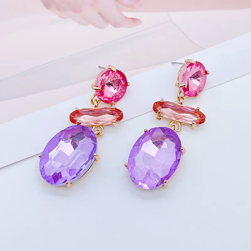 Kristallörhängen i lila och rosa nyanser med hängande design.